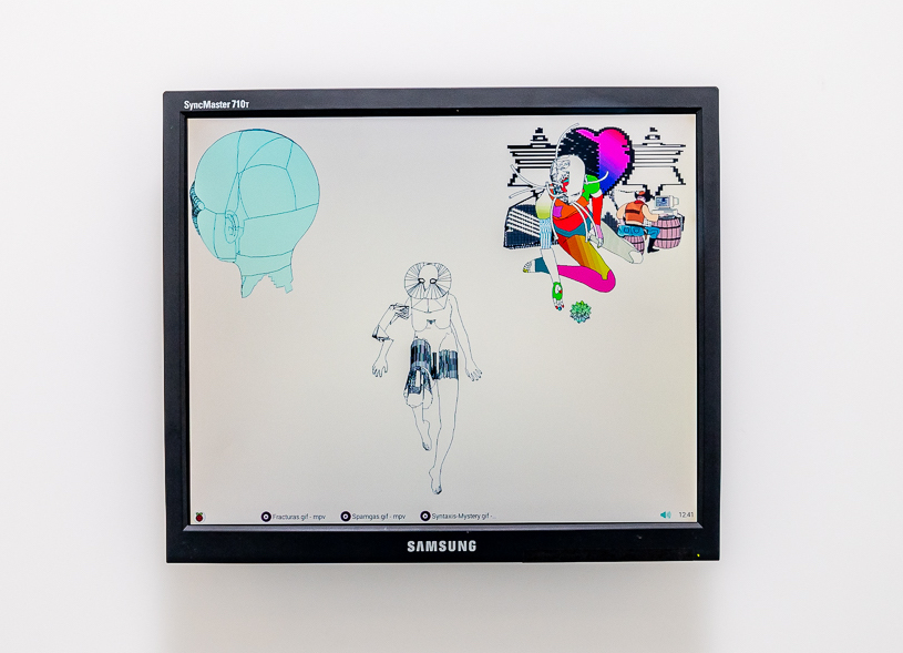 A photo of a monitor attached to a white wall with computer drawings displayed on the screen