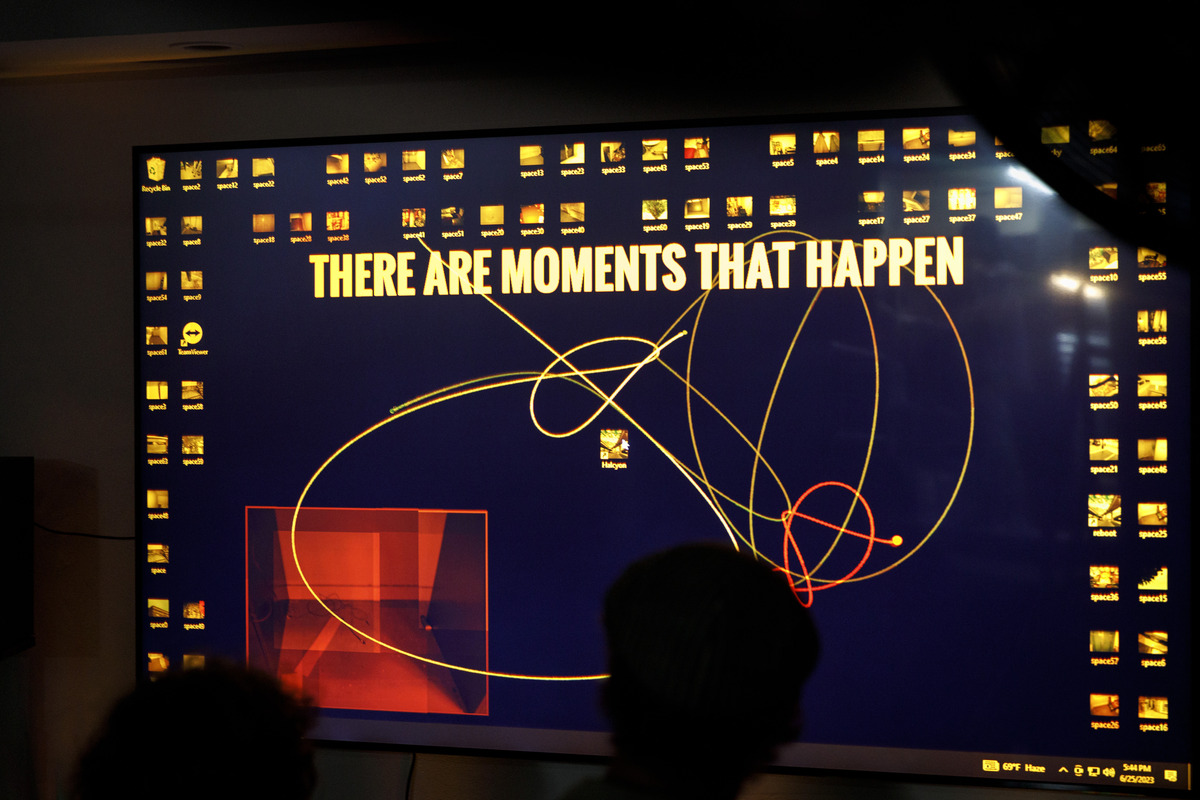 A screen in a gallery shows an animation on a computer desktop, with the text "There are momemnts that happen" in Impact font taking up the center, surrounded by desktop icons
