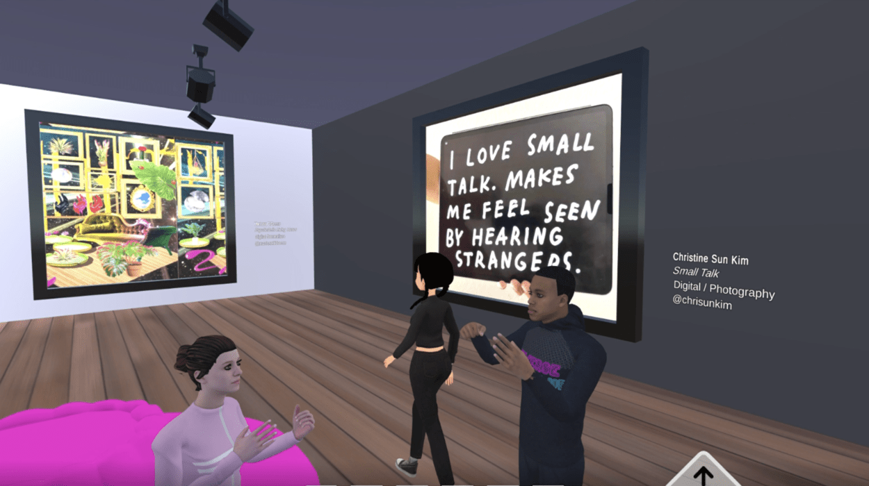 An interior scene in a virtual world. An avatar walks through a room hung with large artworks, and two still figures stand in the middle of the room, their hands frozen in the air while signing
