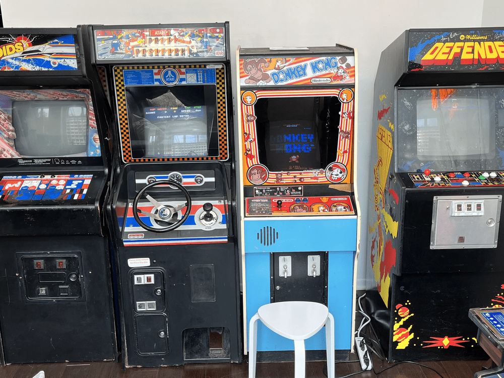 A photograph of vintage arcade cabinets from the 1980s standing in a row.