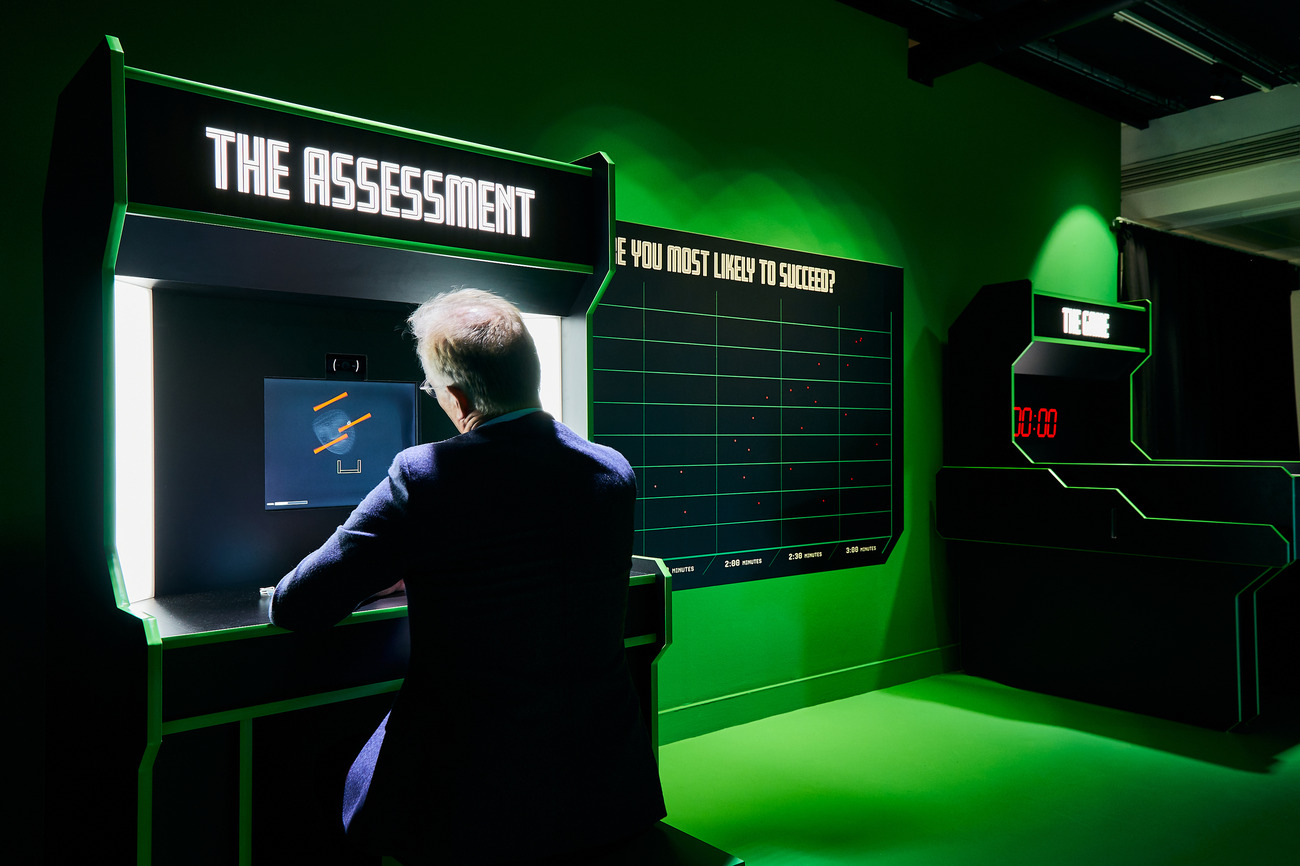 A photograph of a man having his skills assessed by a computer before playing an arcade game