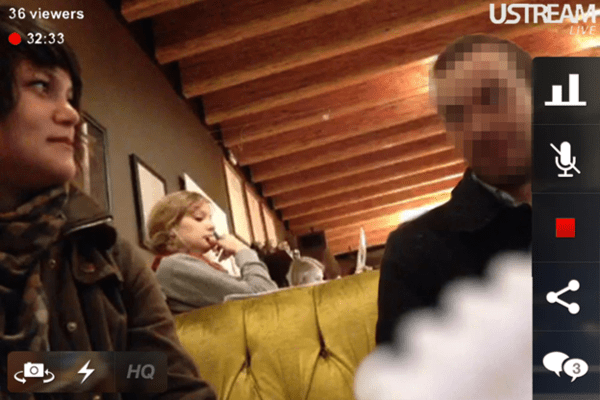 A surreptitious camera shot of two people on a date that is being streamed to a live audience. The man's face is obscured by pixelation